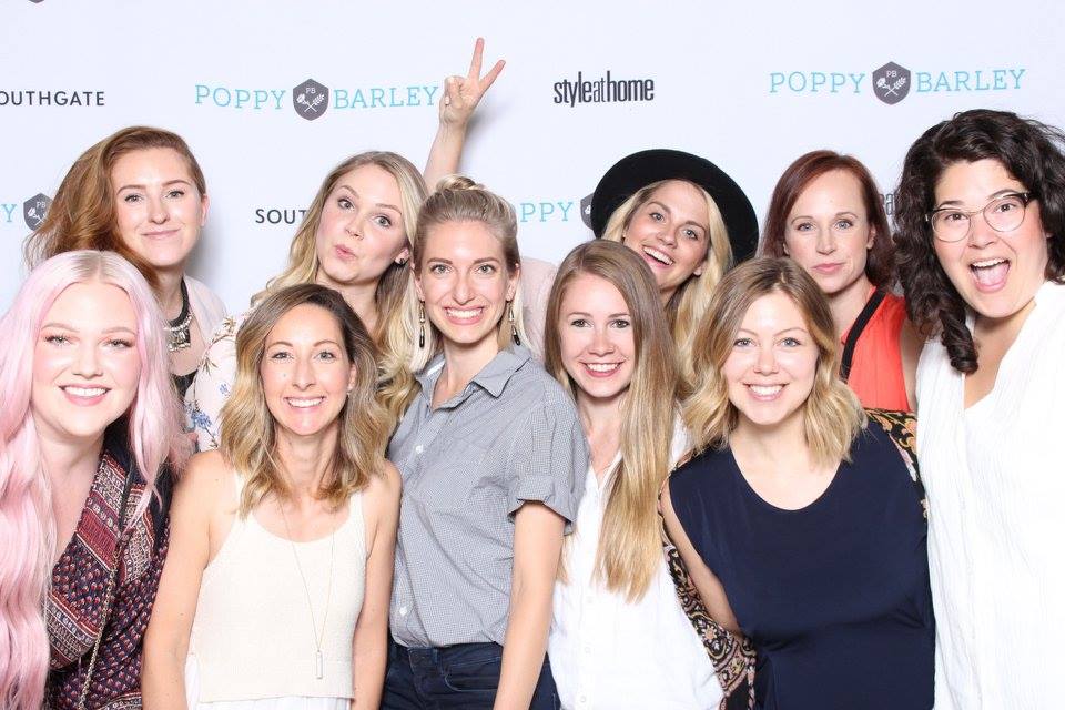 A group of women at a Poppy Barley event using a photo booth 